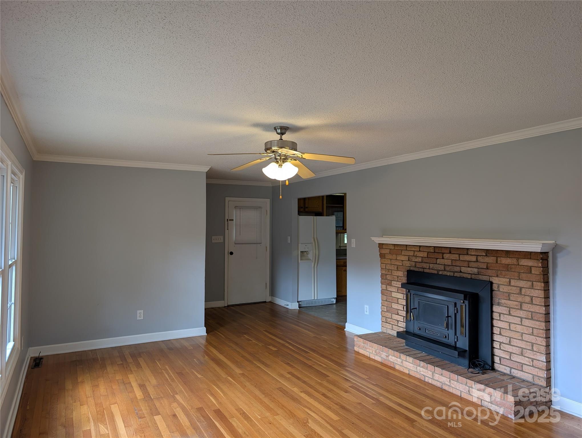 155 Hamptons Cove Road Troutman, NC 28166 - Photo 7 of 22 a view of an empty room with wooden floor fireplace and a window