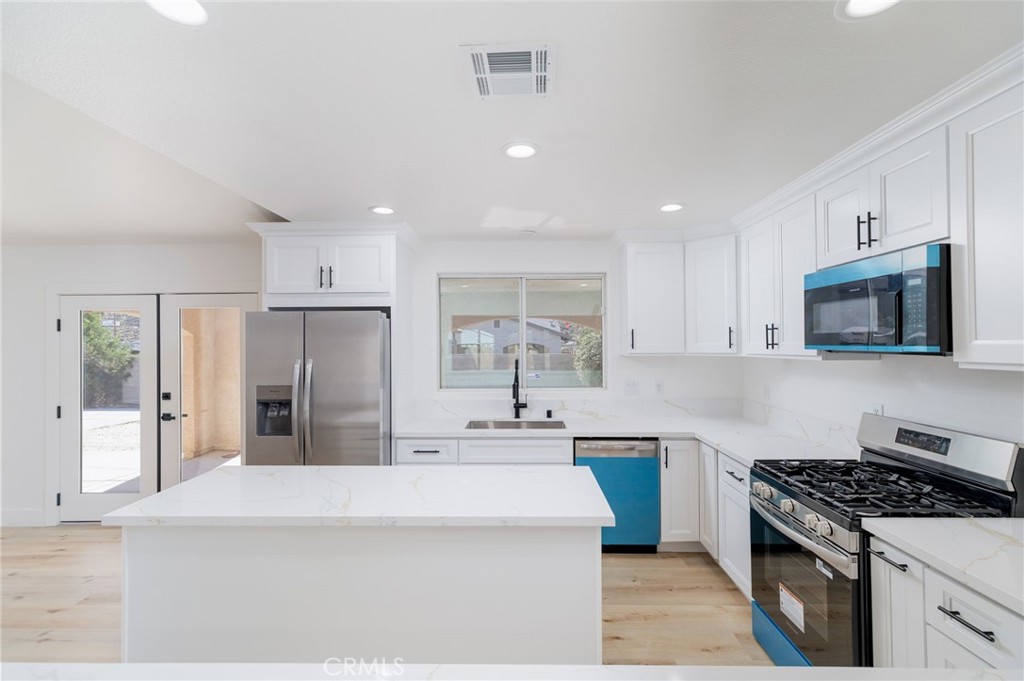 51621 Riza Avenue Cabazon, CA 92230 - Photo 11 of 32 a kitchen with stainless steel appliances a sink stove and refrigerator
