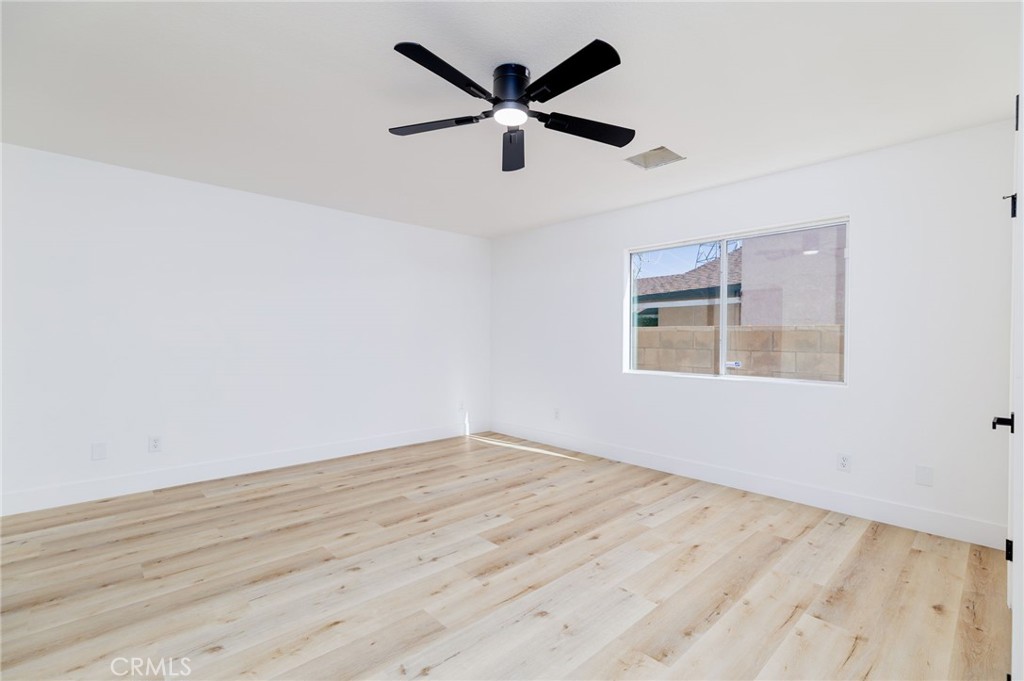 51621 Riza Avenue Cabazon, CA 92230 - Photo 21 of 32 an empty room with wooden floor and ceiling fan