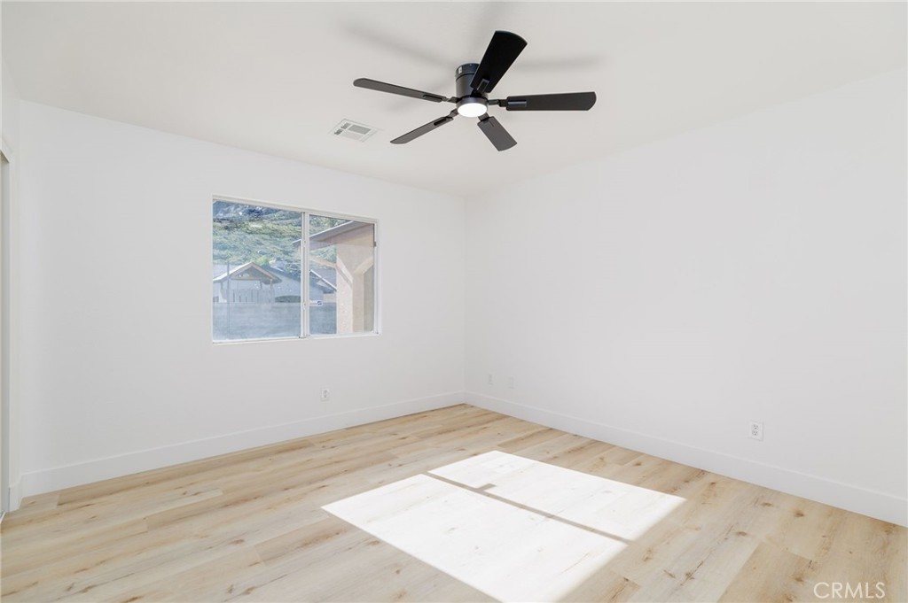 51621 Riza Avenue Cabazon, CA 92230 - Photo 25 of 32 a view of a big room with wooden floor and a ceiling fan