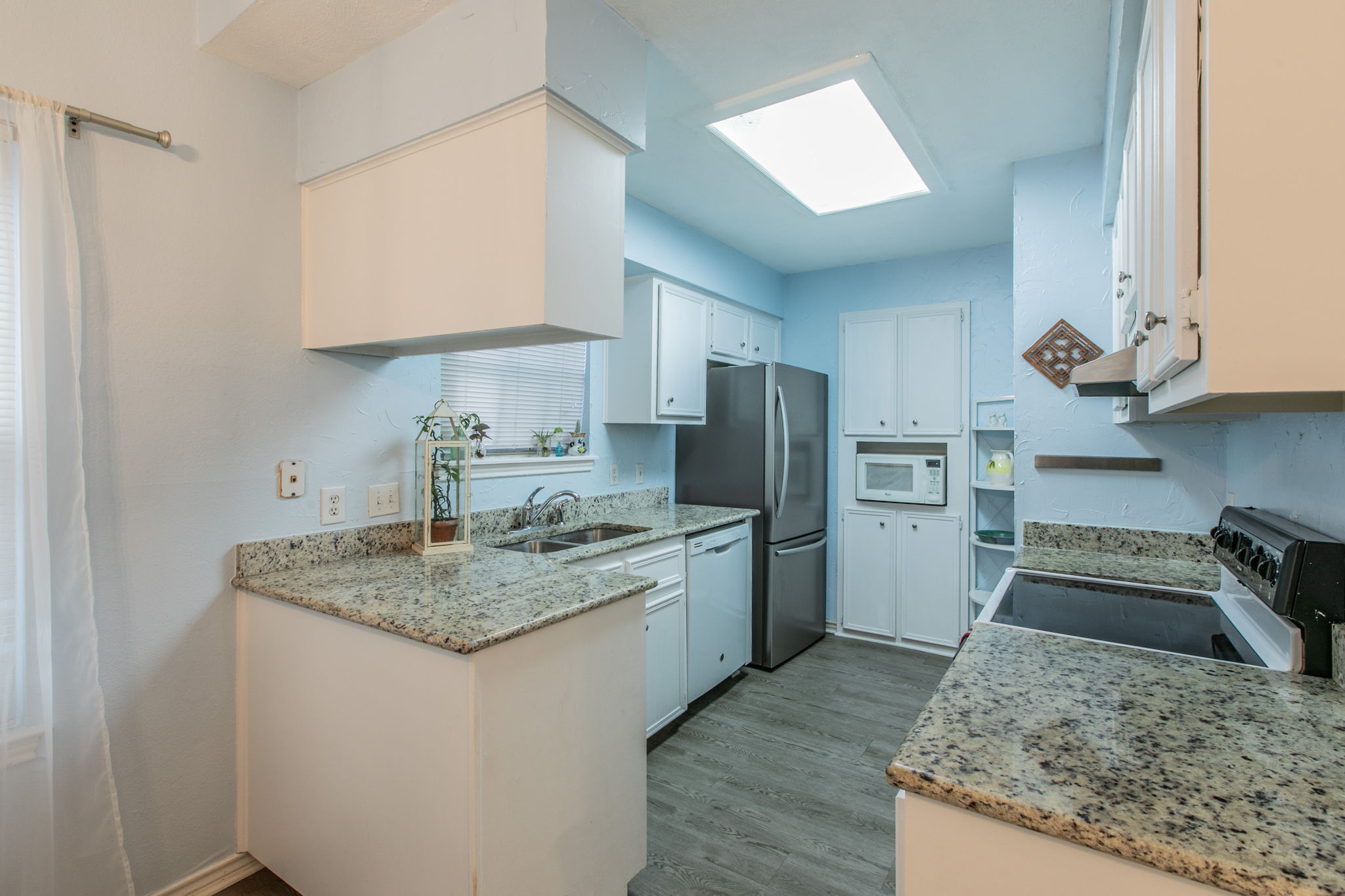 1005 North LBJ Drive, Unit B2 San Marcos, TX 78666 - Photo 4 of 19 a kitchen with stainless steel appliances granite countertop a sink stove and refrigerator