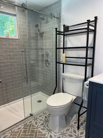 a bathroom with a toilet sink vanity and mirror