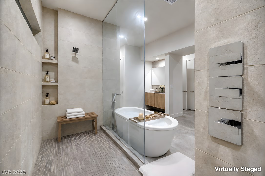 25 Falling Ridge Lane Henderson, NV 89011 - Photo 19 of 48 A refined bathroom featuring a spacious walk-in shower and a freestanding soaking tub.