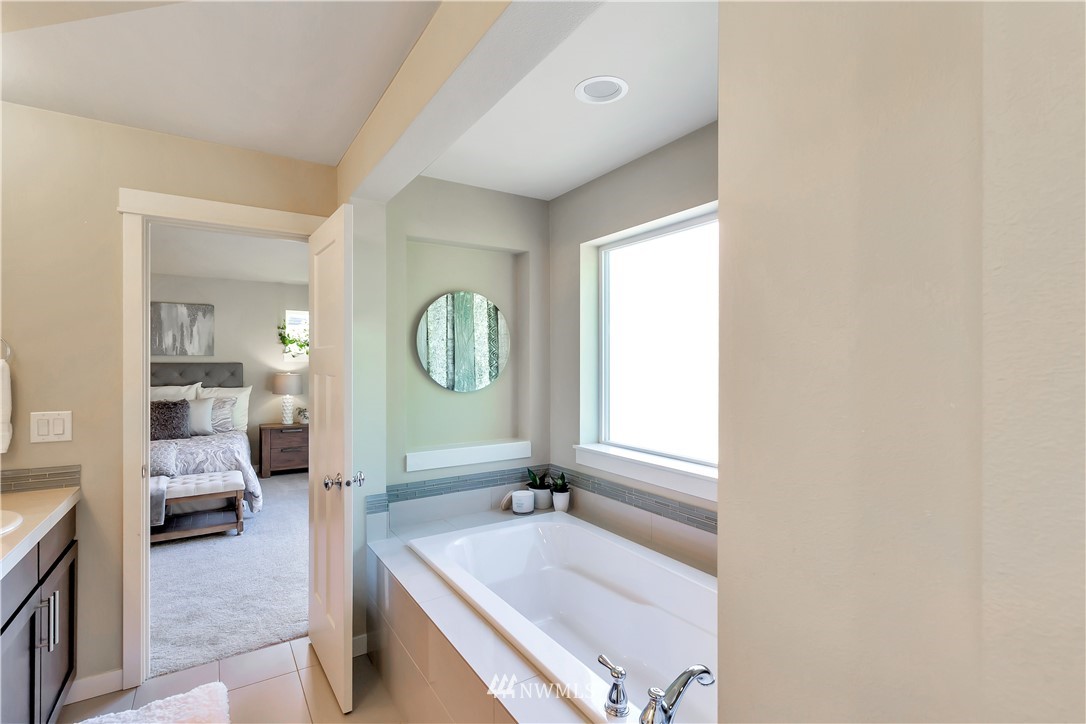 4431 225th Place Southeast Bothell, WA 98021 - Photo 19 of 19 a spacious bathroom with a mirror a bathtub and a shower