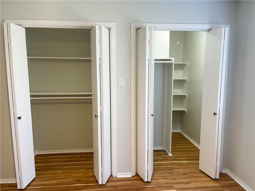 2102 Kenneth Avenue, Unit A Austin, TX 78741 - Photo 12 of 15 Two bi-fold door closets featuring wood-finish flooring, white trim, and light gray wall paint