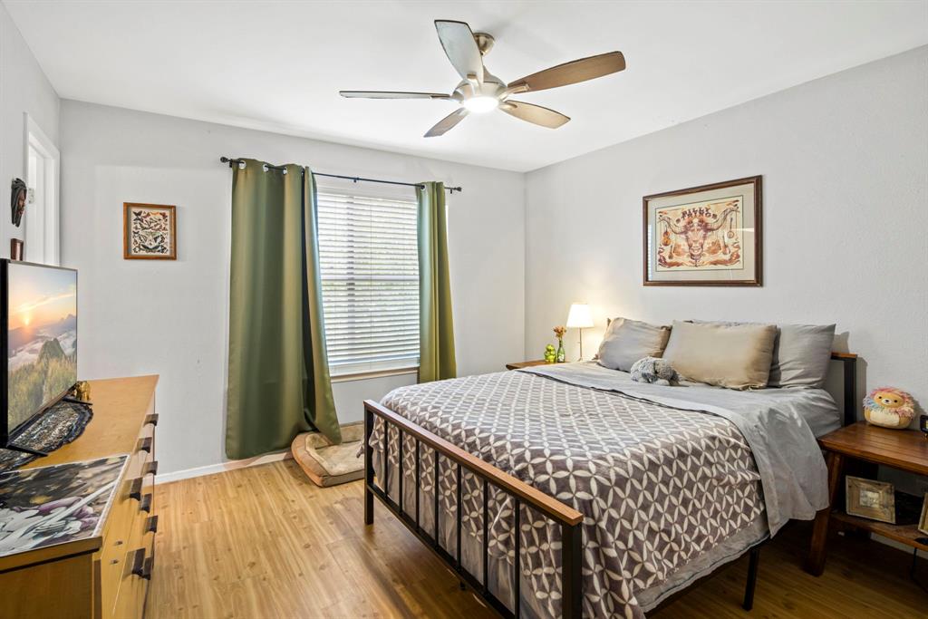 2102 Kenneth Avenue, Unit A Austin, TX 78741 - Photo 8 of 15 Bright room featuring wood-finish flooring, a window with horizontal blinds, and a ceiling fan with integrated lighting