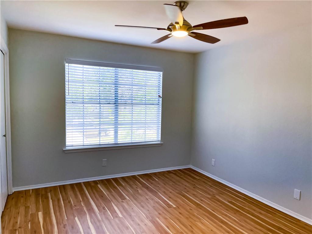 2102 Kenneth Avenue, Unit A Austin, TX 78741 - Photo 9 of 15 Room featuring wood-finish flooring, a window with blinds, a ceiling fan with integrated lighting, and neutral wall tones