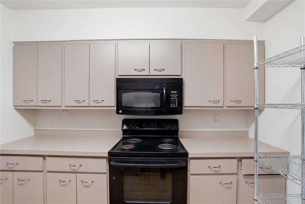 128 North Craig Street, Unit 511 Pittsburgh, PA 15213 - Photo 19 of 46 a kitchen with granite countertop white cabinets and stainless steel appliances