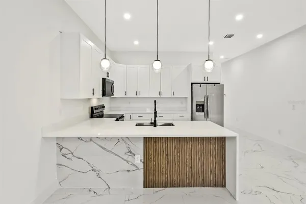 a kitchen with kitchen island a sink stainless steel appliances and cabinets