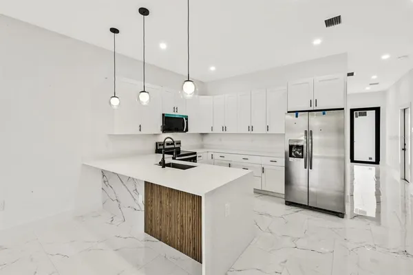 a kitchen with a refrigerator a sink and a oven