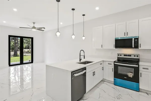 a view of a sink and a refrigerator a mirror on the wall