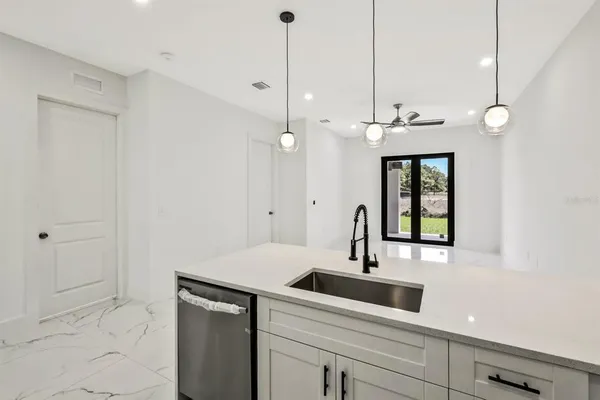 a large white kitchen with a large window