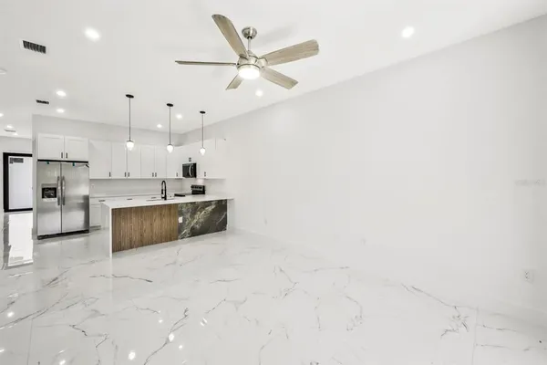 an empty room with windows and fan