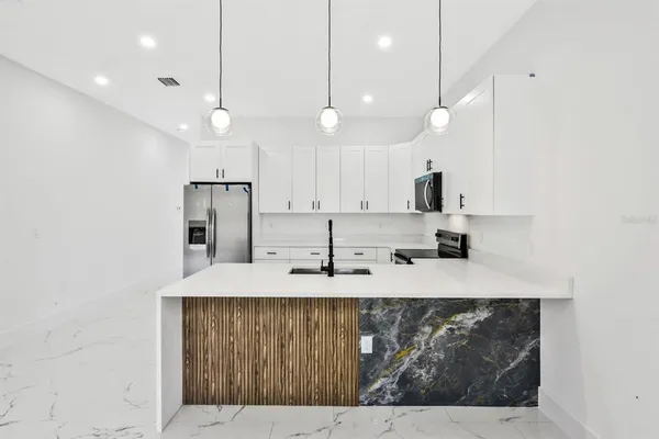 a kitchen with kitchen island a sink stainless steel appliances and cabinets