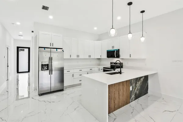 a kitchen with a refrigerator a sink and microwave