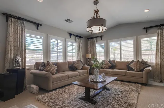 a living room with furniture potted plant and a large window