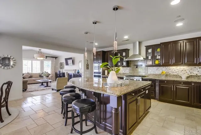 a kitchen with kitchen island granite countertop lots of counter top space and stainless steel appliances