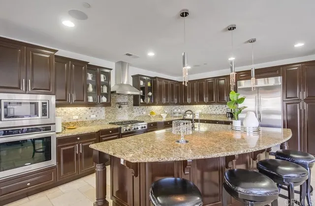 a kitchen with granite countertop a sink stove and cabinets