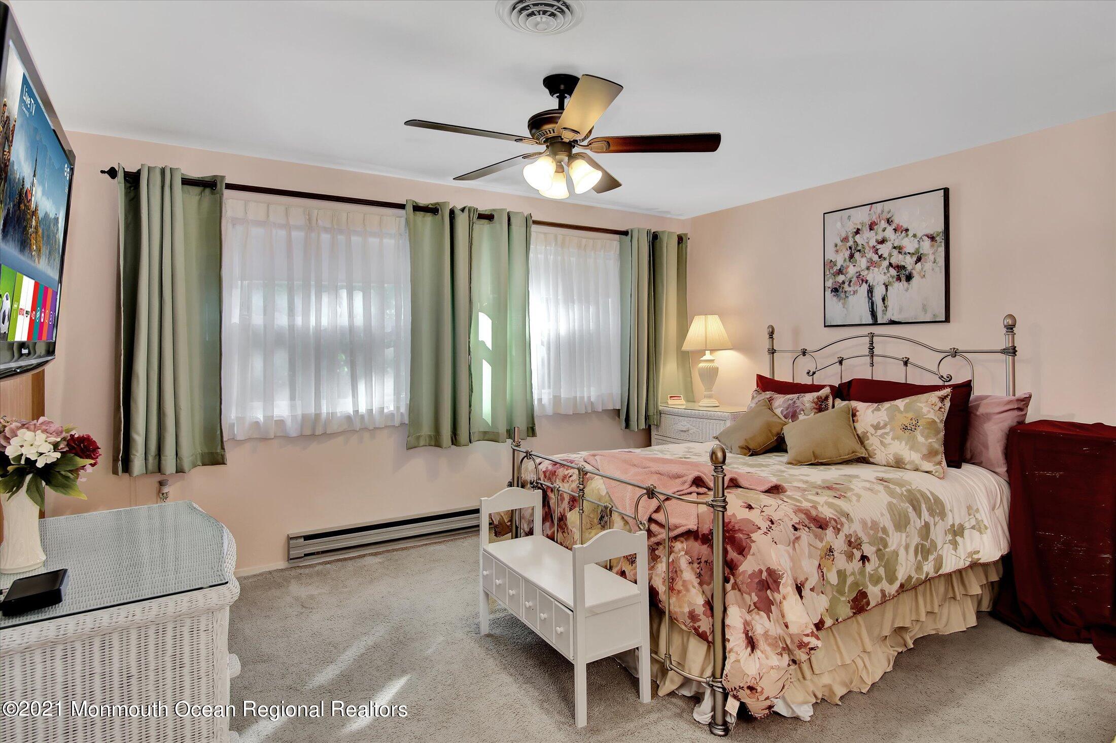 17 Ashley Road Whiting, NJ 08759 - Photo 22 of 31 a bedroom with a large bed and a chandelier