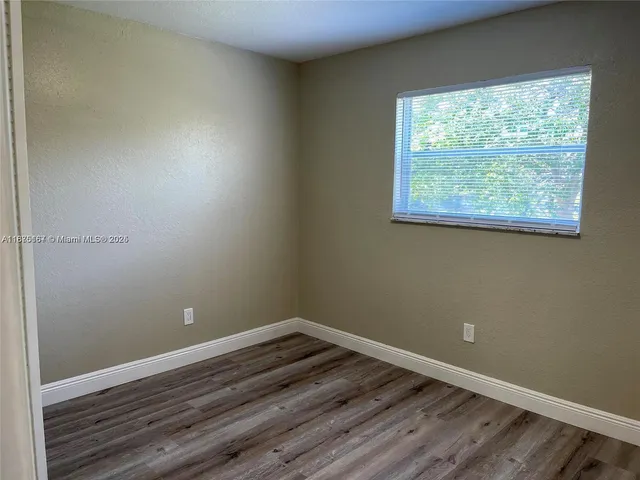 a room with a window and wooden floor