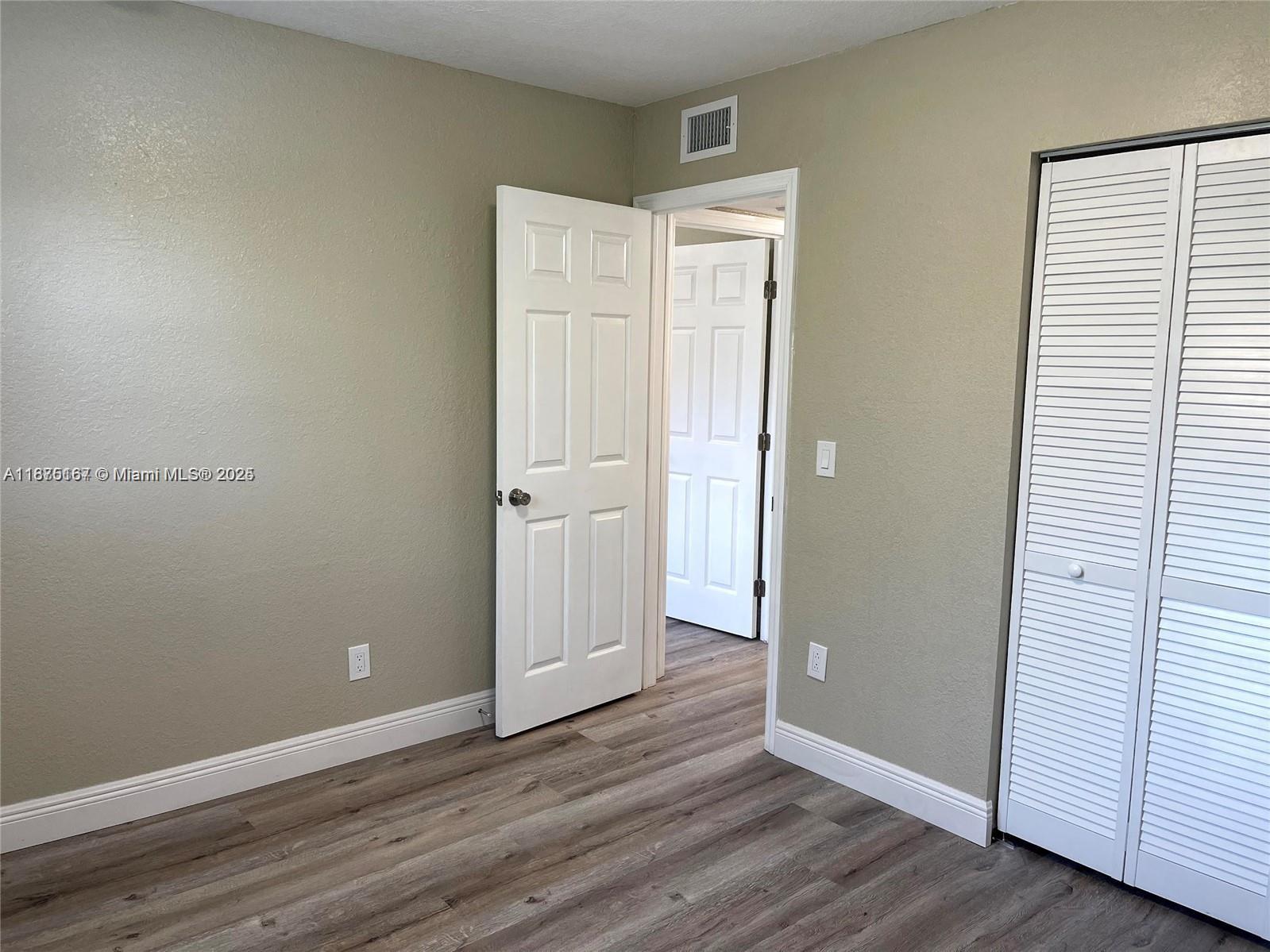 400 Northwest 65th Avenue, Unit 120 Margate, FL 33063 - Photo 14 of 17 an empty room with wooden floor and closet