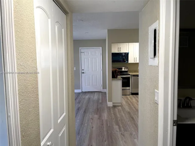 a view of a hallway with wooden floor and staircase
