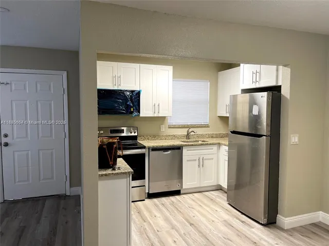 a kitchen with a refrigerator sink and stove