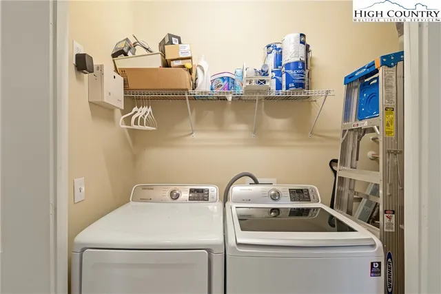 a view of a white house with a big yard and couches chair