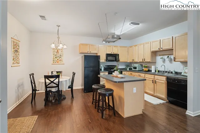 a kitchen with a table chairs microwave and cabinets
