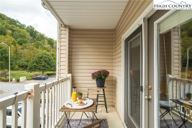a view of a balcony with wooden floor and outdoor seating