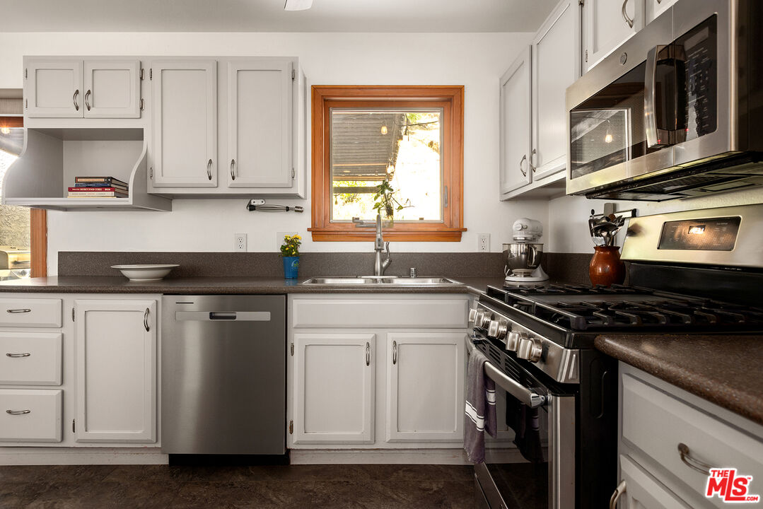865 Katherine Road Simi Valley, CA 93063 - Photo 7 of 25 a kitchen with stainless steel appliances granite countertop a sink stove top oven and cabinets