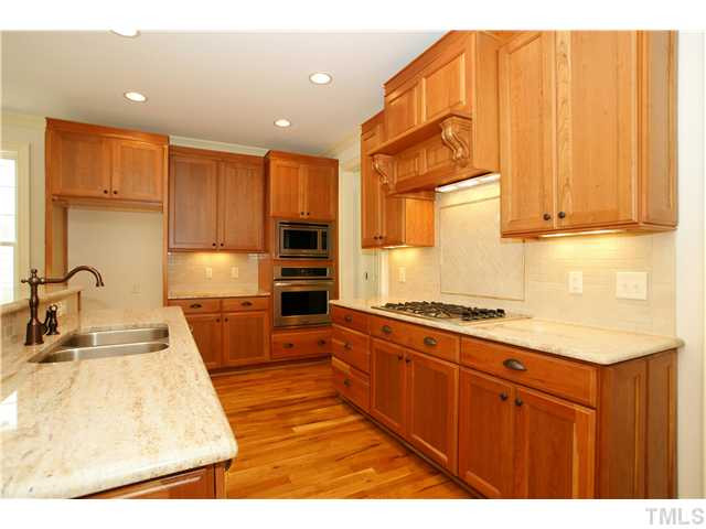 405 Redhill Road Holly Springs, NC 27540 - Photo 8 of 25 Warm hardwood floors throughout the first floor Kitchen