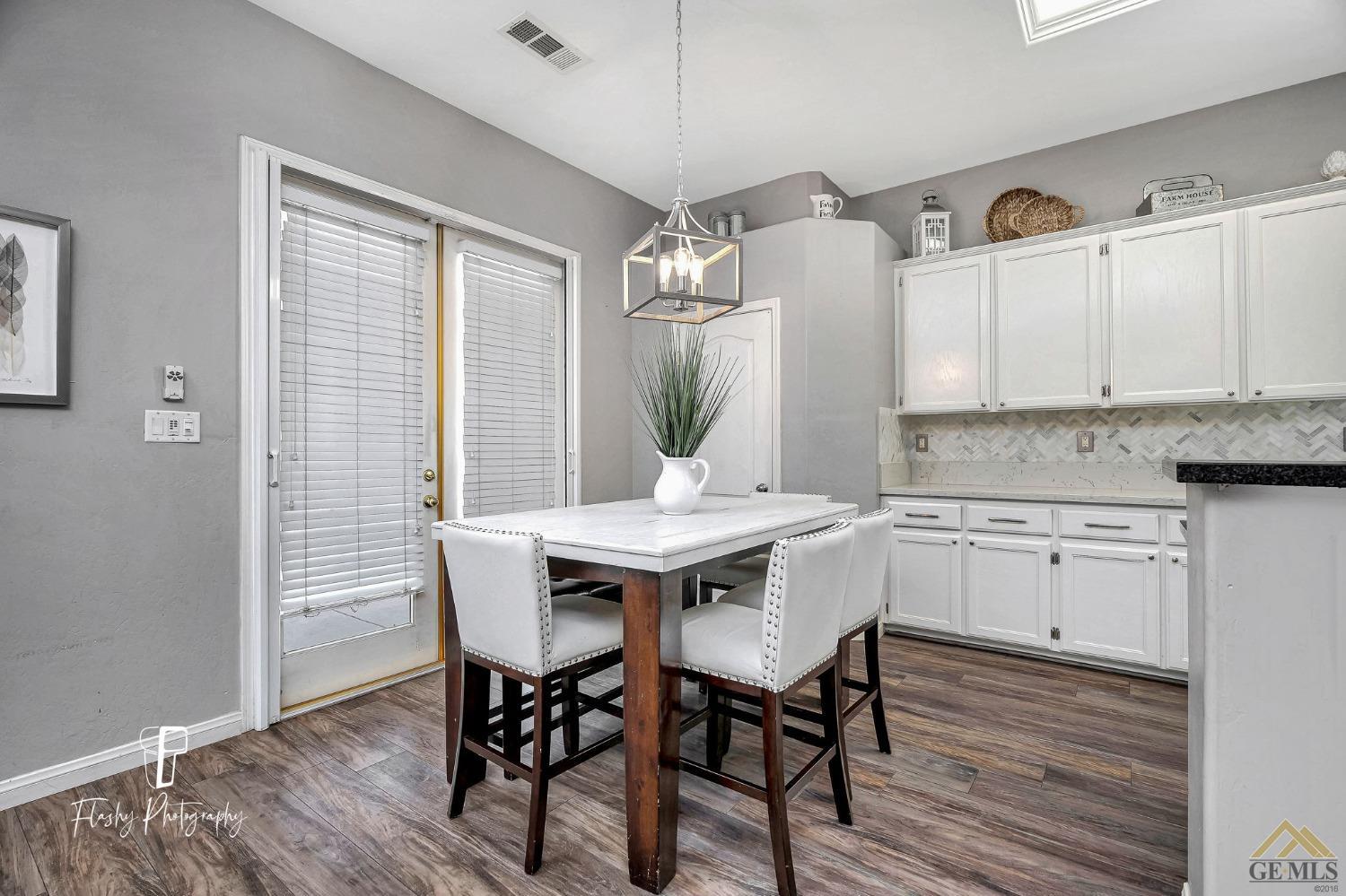 Undisclosed Address Bakersfield, CA 93311 - Photo 15 of 55 a kitchen with a table chairs sink and cabinets