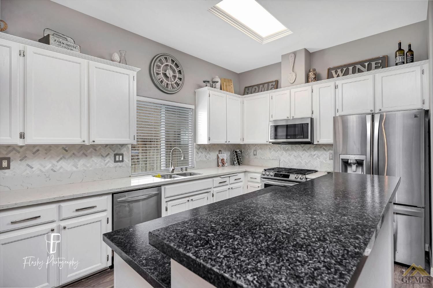Undisclosed Address Bakersfield, CA 93311 - Photo 17 of 55 a kitchen with a sink a stove a refrigerator and white cabinets