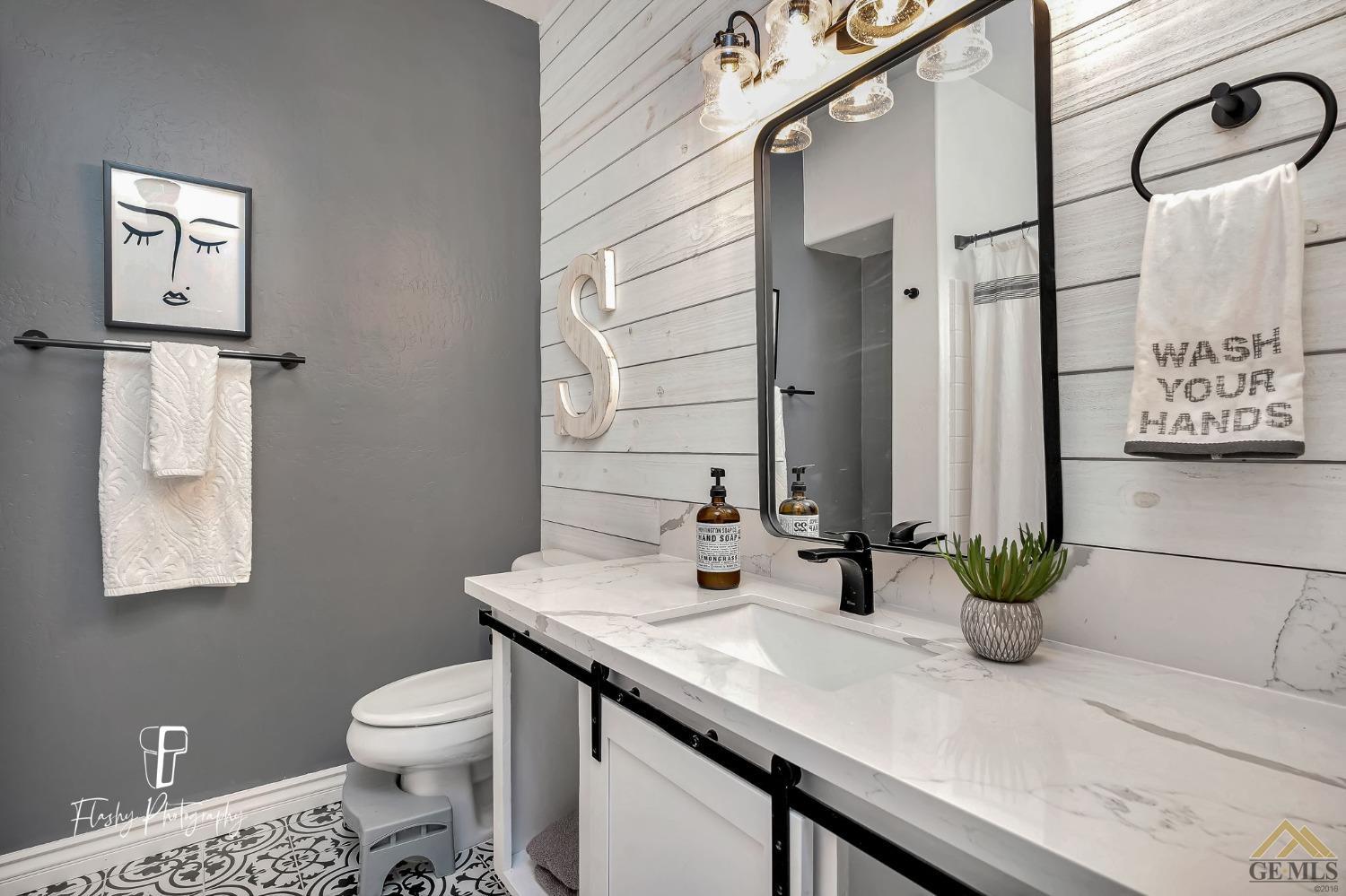 Undisclosed Address Bakersfield, CA 93311 - Photo 21 of 55 a bathroom with a toilet sink and mirror