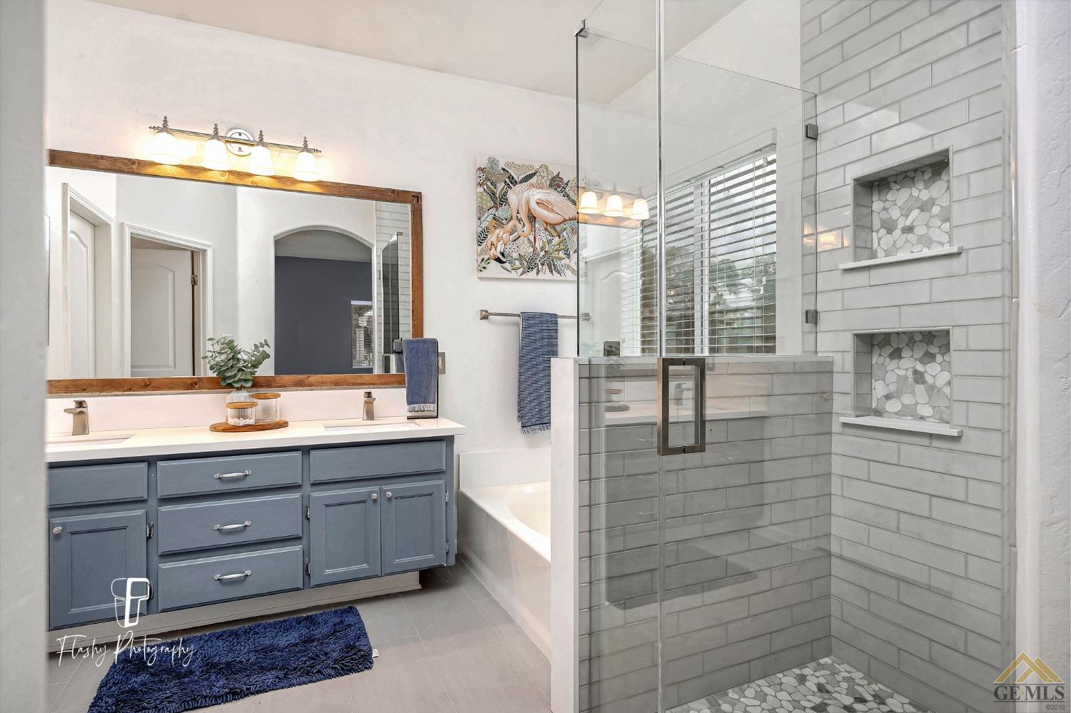 Undisclosed Address Bakersfield, CA 93311 - Photo 30 of 55 a bathroom with a granite countertop sink a mirror and shower