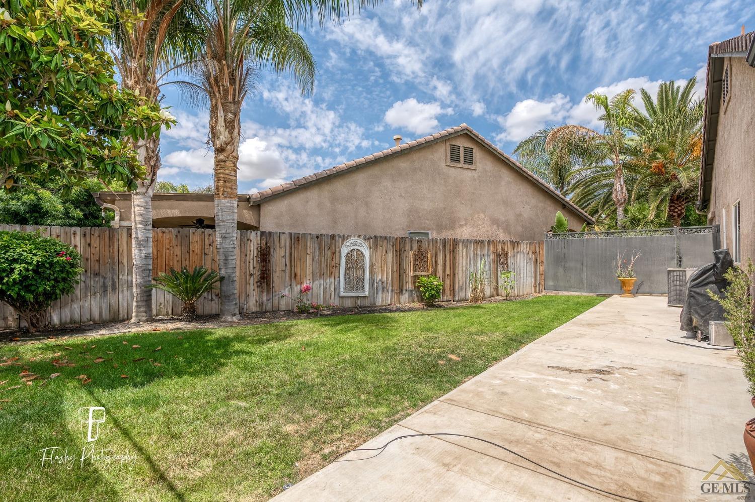 Undisclosed Address Bakersfield, CA 93311 - Photo 45 of 55 a front view of a house with a yard and potted plants