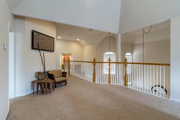 a view of a hallway with chairs and couches with wooden floor