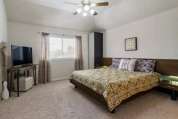 a bedroom with a bed and a flat screen tv