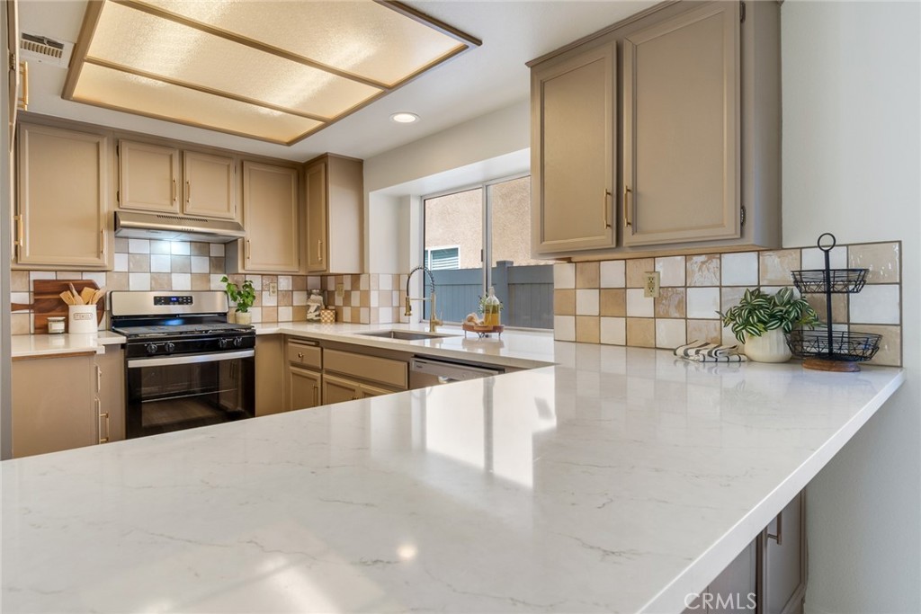 3682 North Pole Lane Riverside, CA 92503 - Photo 13 of 30 a kitchen with stainless steel appliances granite countertop a sink a stove top oven a counter space and cabinets