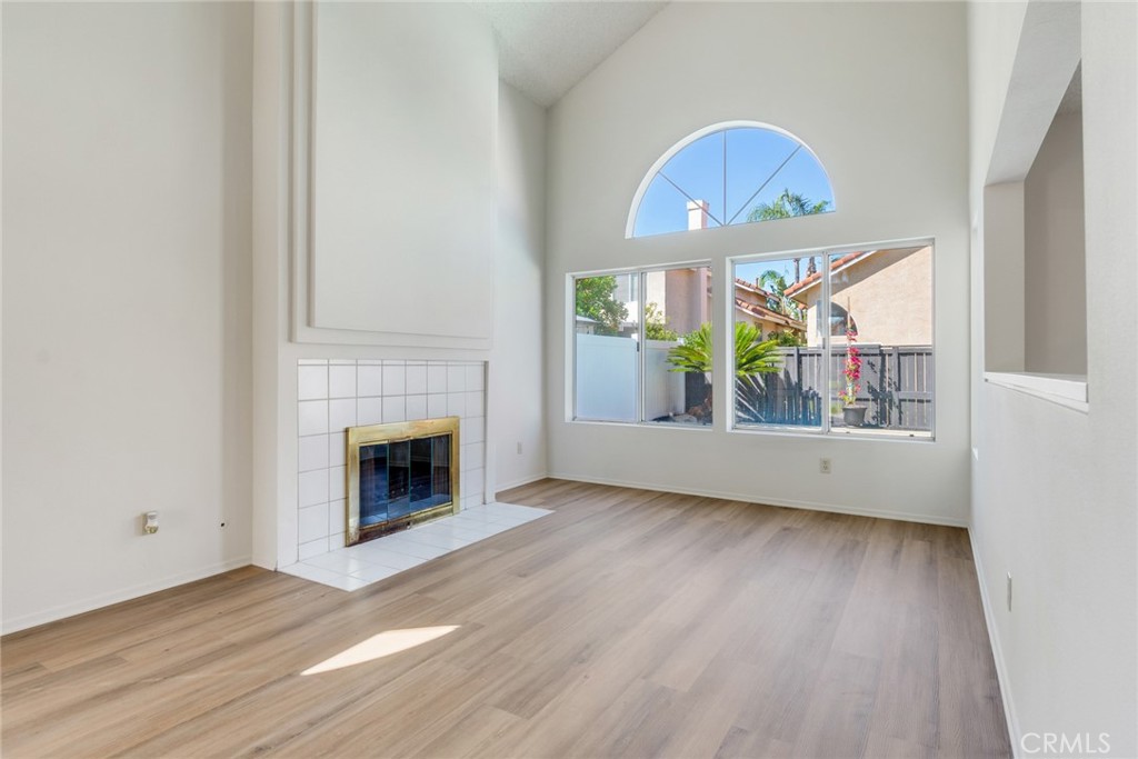 3682 North Pole Lane Riverside, CA 92503 - Photo 7 of 30 an empty room with wooden floor a fireplace and windows