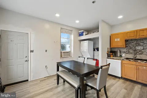 a kitchen with a table chairs and wooden floor