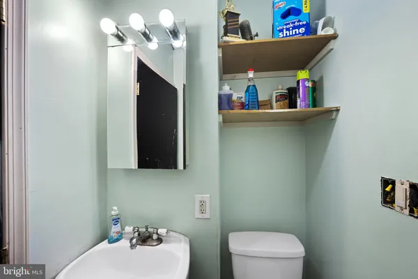 a bathroom with a toilet sink and mirror