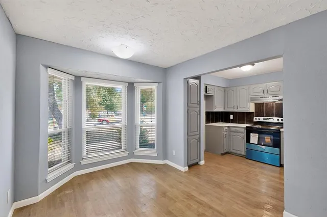 a view of kitchen with stainless steel appliances kitchen island wooden floor and window