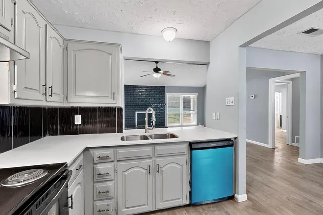 a kitchen with a sink and a stove top oven