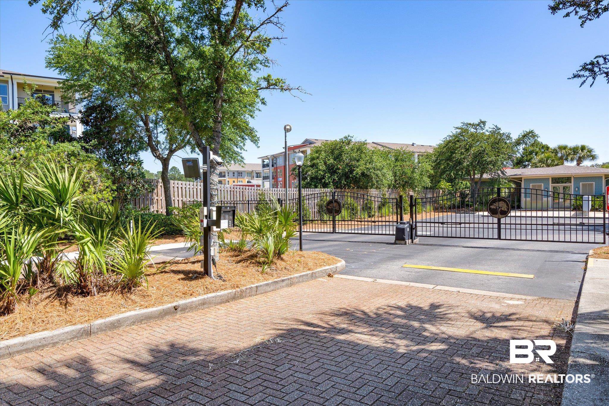 1430 Regency Road, Unit C103 Gulf Shores, AL 36542 - Photo 22 of 29 View of decorative road featuring a gate, a gated entry, curbs, and street lighting