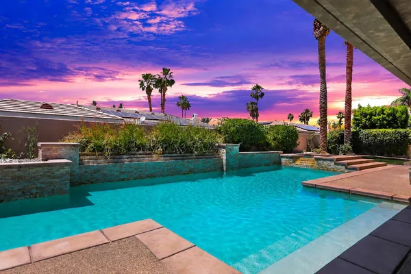 a view of a swimming pool with a table and a lake view