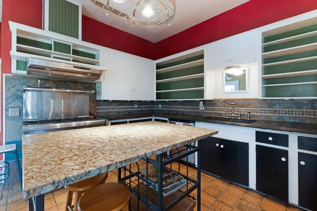 a stove top oven sitting inside of a kitchen