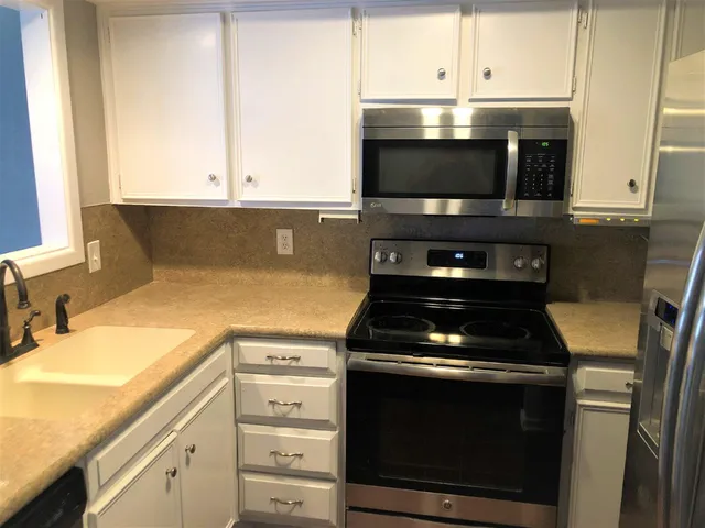 a kitchen with granite countertop a stove and a microwave
