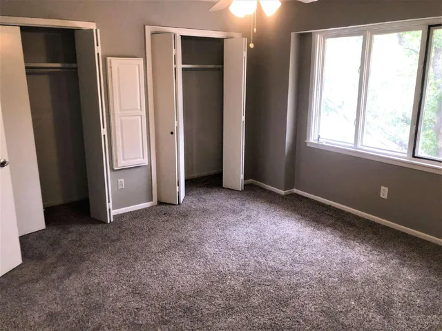 an empty room with windows and closet
